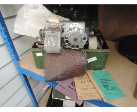 A vintage bus conductors ticket machine in tin with tickets and spare money bags 
