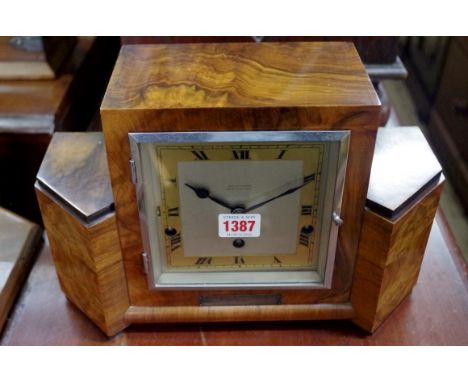 An Art Deco walnut and ebonized mantel clock,&nbsp;striking on eight gongs, 33cm wide. 