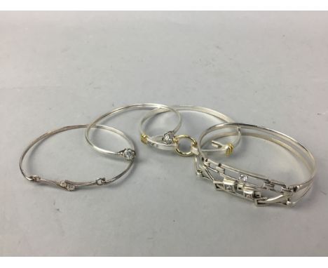 FOUR SILVER BANGLES, including a bi-colour bangle and a gem set example