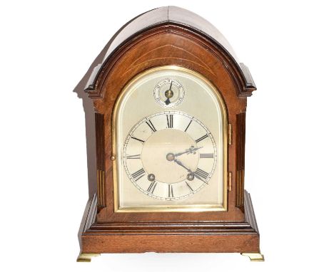 A late 19th century German mahogany cased striking mantel clock with a silvered arched top dial and having brass beveled and 