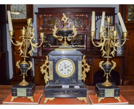 A 19th century French slate and green onyx cased mantel clock garniture, with enamel dial and striking on a bell, 54cm high