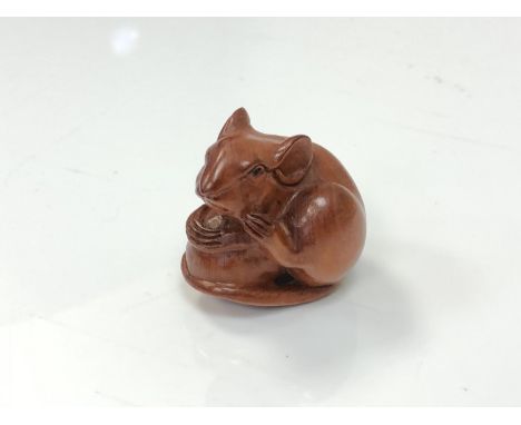 A carved Chinese hardwood netsuke - Rat sat on a nut 