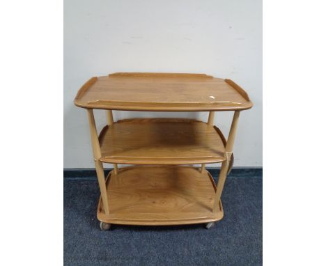 An Ercol elm and beech three tier tea trolley on castors 