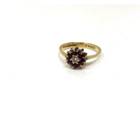 An 18ct gold ruby and diamond cluster ring, size O.  CONDITION REPORT: 2.9g