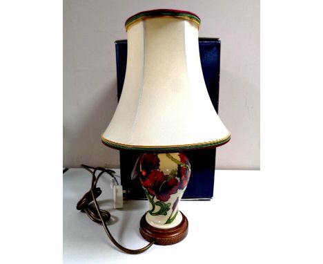 A Moorcroft table lamp with red flowers on cream ground, height of lamp base 19cm, with shade, boxed. 