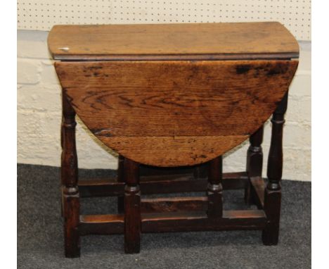 An early 18th century oak drop leaf gate leg table of small proportions. 60 x 92 x 70cm (open)