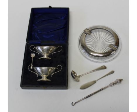 A cased, matched pair of silver navette form twin handled salts, a presentation silver mounted ashtray, sauce ladle, butter k