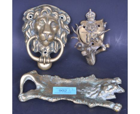 An assortment of three vintage 20th century brass items to include a desk ornament in the form of a lion skin rug, a lions he