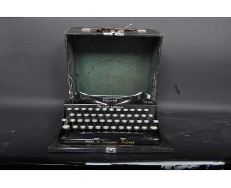 A 1940's vintage metal Imperial typewriter in black qwerty form with gilt details and the Royal crest, in the original carryc