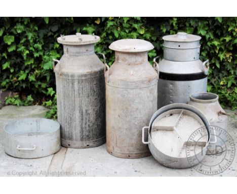 Three vintage milk churns, of various design, tallest 72cm, with a smaller milk churn and two cheese moulds (6)