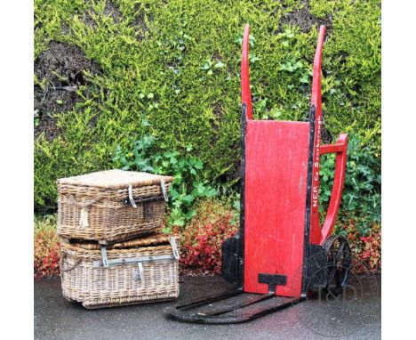 A vintage railway station red painted luggage trolley, named for NER Scarborough, 164cm long, with two wicker baskets (at fau