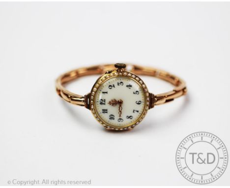 A seed pearl set lady's wristwatch, early 20th century, the circular face with seed pearl set bezel, enclosing a white enamel