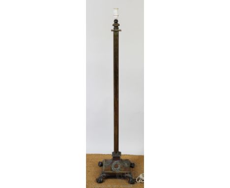 An Edwardian brass adjustable standard lamp, of square form, on laurel wreath decorated square base and claw and ball feet 12