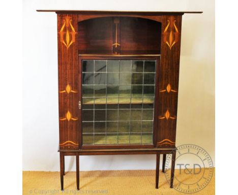 An inlaid Art Nouveau cabinet in the manner of Shapland and Petter, with a shelf and lead glazed door, flanked by panels inla