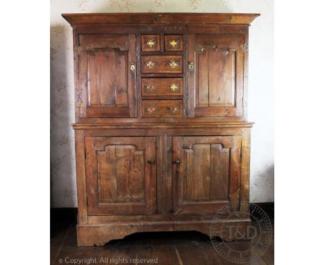 An 18th century provincial Welsh oak deuddarn, with carved date '1773' above an arrangement of five drawers and two panelled 