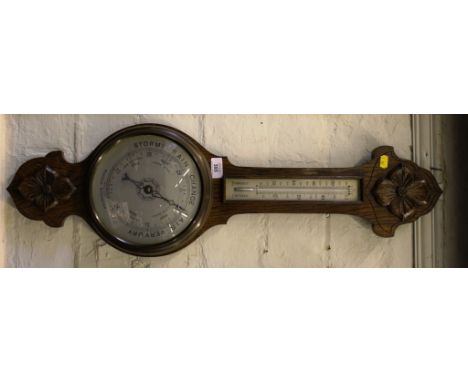 An early 20th century oak stained banjo aneroid barometer with applied oak rosettes, 80cm long  
