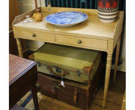 An early 19th century pine writing table with 3/4 gallery, two drawers under with circular brass handles, raised on turned le