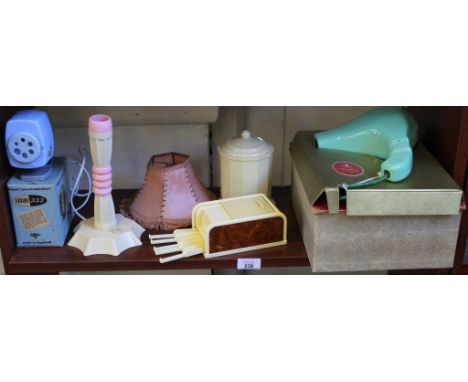 Vintage plastics, including Rolinx roll-top cigarette dispenser, pink and cream lamp with shade, velos pencil sharpener, cadd