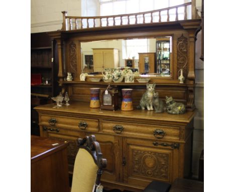 An Arts and Crafts light oak chiffonier with spindle supports to the superstructure, oblong bevelled mirror with shelf, shape