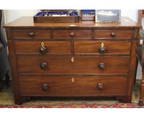 A Victorian mahogany and cross banded chest of five small and two large drawers with shaped top, ring turn handles with lozen