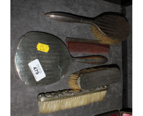 A lady's silver and five piece mirror and brush set