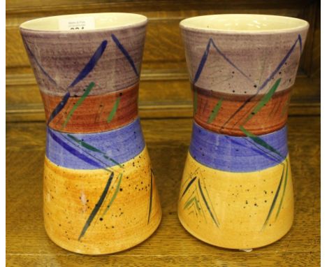 A pair of Poole hand thrown ceramic vases of waisted form with multicoloured isometric designs 