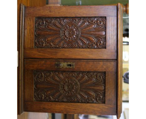 An Arts and Crafts oak stained pipe tobacco cabinet with lift up lid, fitted interior with two small drawers with brass drop 