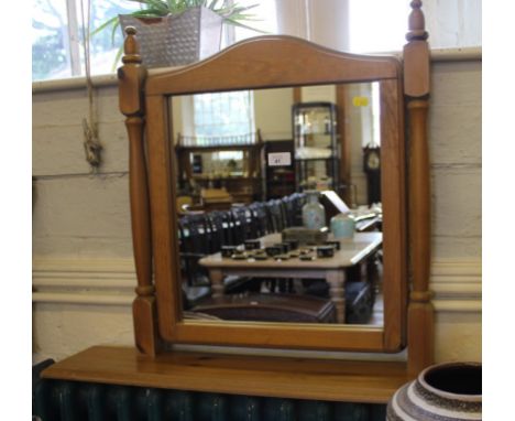 A contemporary pine vanity mirror with oblong plate, twin turned supports on a platform base