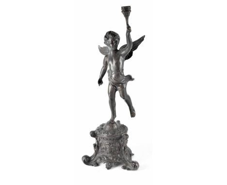 An ebonised bronze figure of a cherub holding aloft a torch, standing on a Baroque-style base with three scroll feet, height 