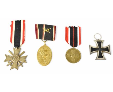 A WWII German Bronze War Merit Cross with remains of packet of issue, a War Merit Medal in Bronze, a WWI Second Class Iron Cr