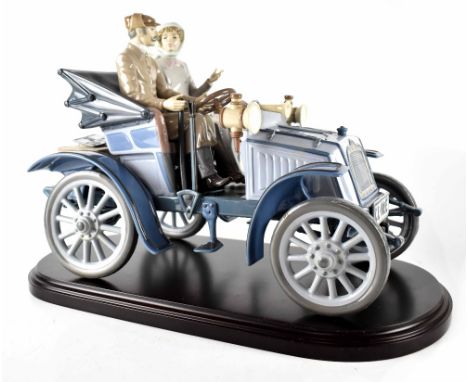 A Lladró limited edition figure group 5884 'Motoring in Style', depicting a couple in a vintage car, on wooden base and with 