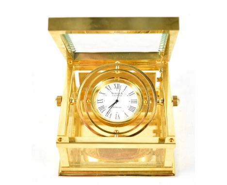 A boxed Sewills brass-cased gimbal mantel clock, the dial set with Roman numerals, 8 x 8cm.