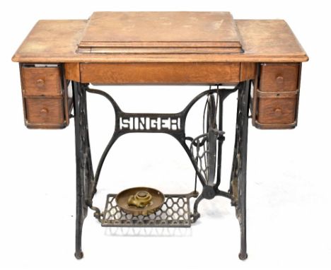 A vintage oak-cased Singer treadle sewing machine.