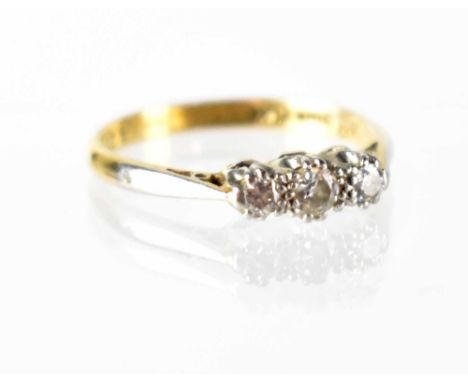 An 18ct gold three-stone diamond ring, the three platinum claw-set small diamonds approx 0.16ct, size K, approx 2.1g.