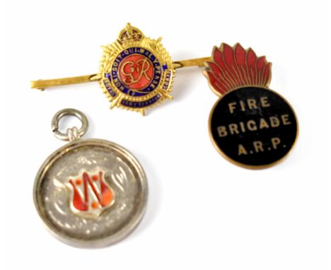 A Royal Army Service Corp enamelled badge, Fire brigade A.R.P black enamelled badge and a silver schools prize fob for runnin