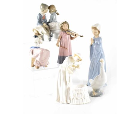 A group of Nao figures comprising 1034 'Nina Violin', 0245 'Patito Optimista', 1049 'Cachorrillo Mimado', 1136 'Primer Amor',