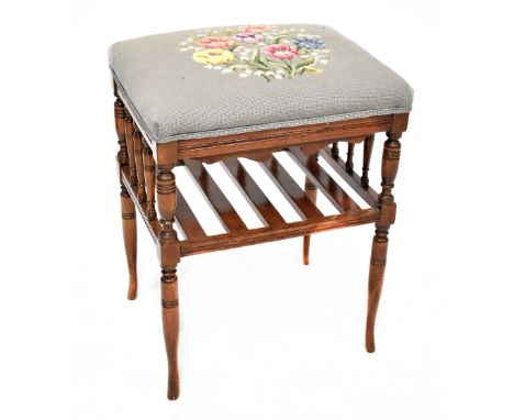 An Edwardian beech piano stool with rectangular tapestry top, with slatted under shelf, on slender out-turned legs, height 56