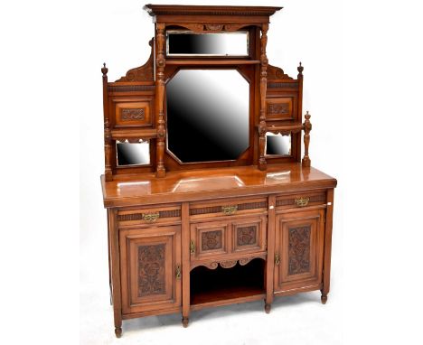 An Edwardian mahogany mirror-back sideboard, the central carved frieze above two central mirrors, shelves to either side supp