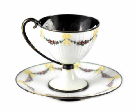 M HAMMER; a silver and enamel chocolate cup and saucer, ivory enamel with floral swags and bow decoration, marked to the base