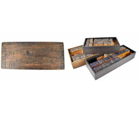 Three boxes of printing blocks, alphabet and numbers in various typefaces and a carved wooden panel depicting the base and tr