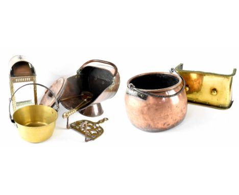 A quantity of copper and brass ware to include a lidded copper cauldron, coal scuttle, brass fire front, jam pan, poker, tong