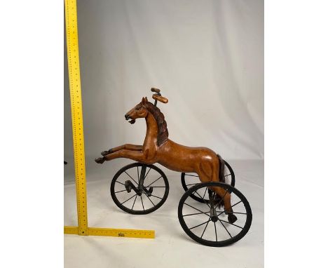 A child's carved wooden tricycle in the form of a horse, approximately 76 cm (h).

NOTE: ITEM IS LOCATED IN THE L34 POSTCODE 