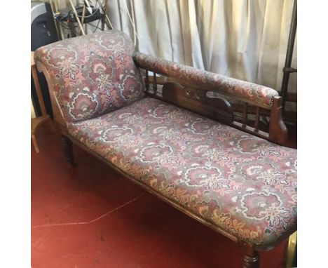 An upholstered chaise longue with turned, castored, supports.

NOTE: ITEM IS LOCATED IN THE L34 POSTCODE AREA. THE SUCCESSFUL