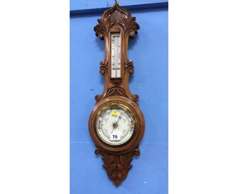 A barometer with carved oak case