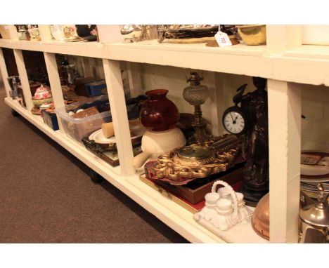 Full shelf of glass, china, silver plate, Le Creuset pans, oil lamp, barometers, figure clock and collectables