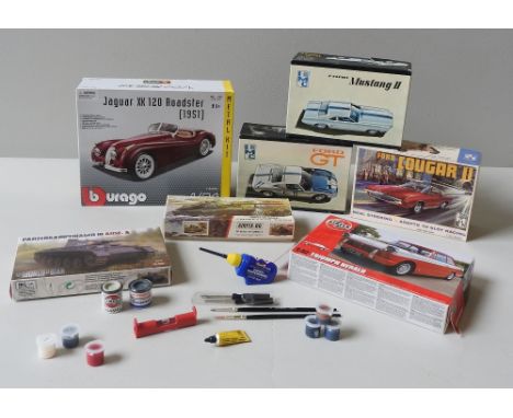 AN IMC VINTAGE MODEL KIT OF A FORD COUGAR II, TWO OTHERS OF A MUSTANG II AND A FORD GT, ALL PARTIALLY MADE, A BURAGO XK120 RO