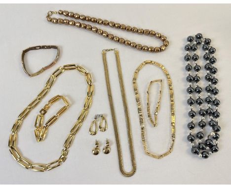 A collection of vintage gold tone and metallic tone jewellery. To include a Greek key matching design necklace &amp; bracelet