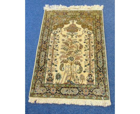 A Persian wool and silk carpet light brown ground with tree of life design and repeating floral border, 163 x 105.5cm