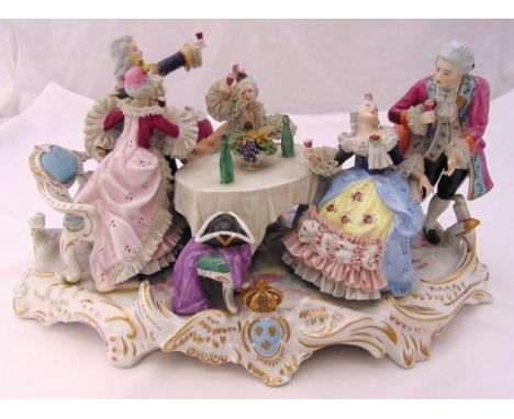 A Crown Naples ceramic figural group of figures drinking and dining in 18th century costume on raised oval base, 27 x 51cm A/
