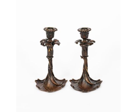 A pair of patinated bronze candlesticks possibly American, each modelled as an Art Nouveau flower stem, the bud sconce with a